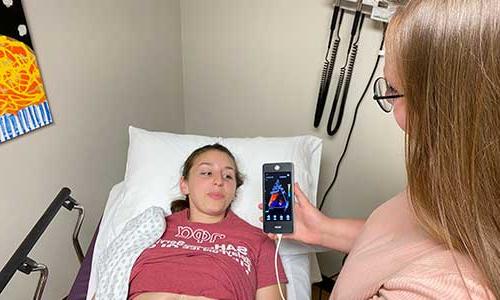 一个躺在医院病床上的女人拿着手机.