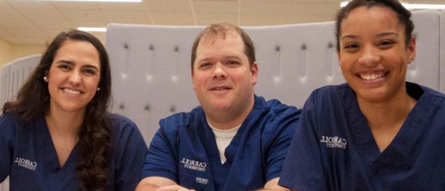 三位面带微笑的医护人员穿着印有博天堂官方入口登陆登录标志的消毒服.